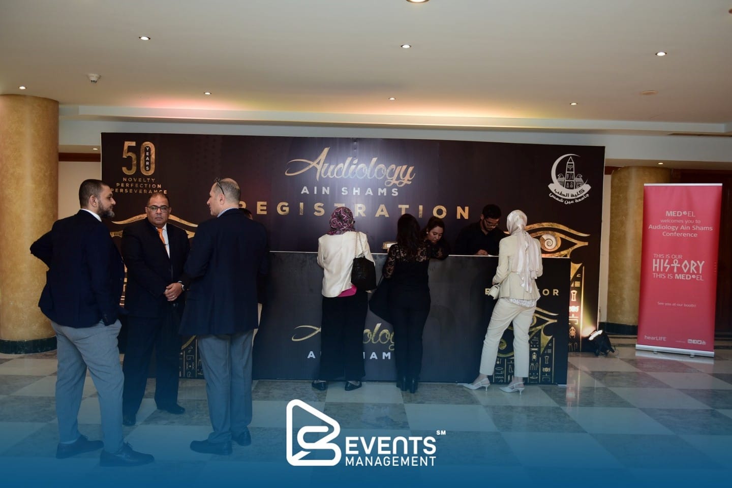 Delegates checking in at the gold pharaonic-themed registration backdrop of Audiology Ain Shams in Luxor